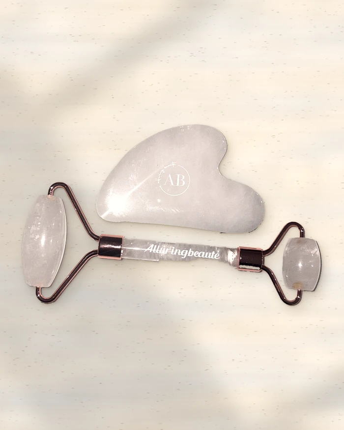 Clear quartz roller and gua sha on stone