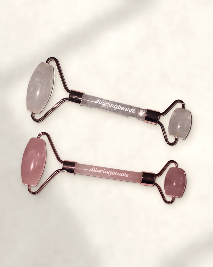 Rose quartz and clear quartz face rollers on stone